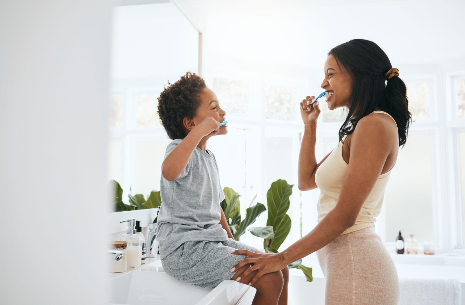 Image d’une personne se brossant les dents en même temps que son enfant